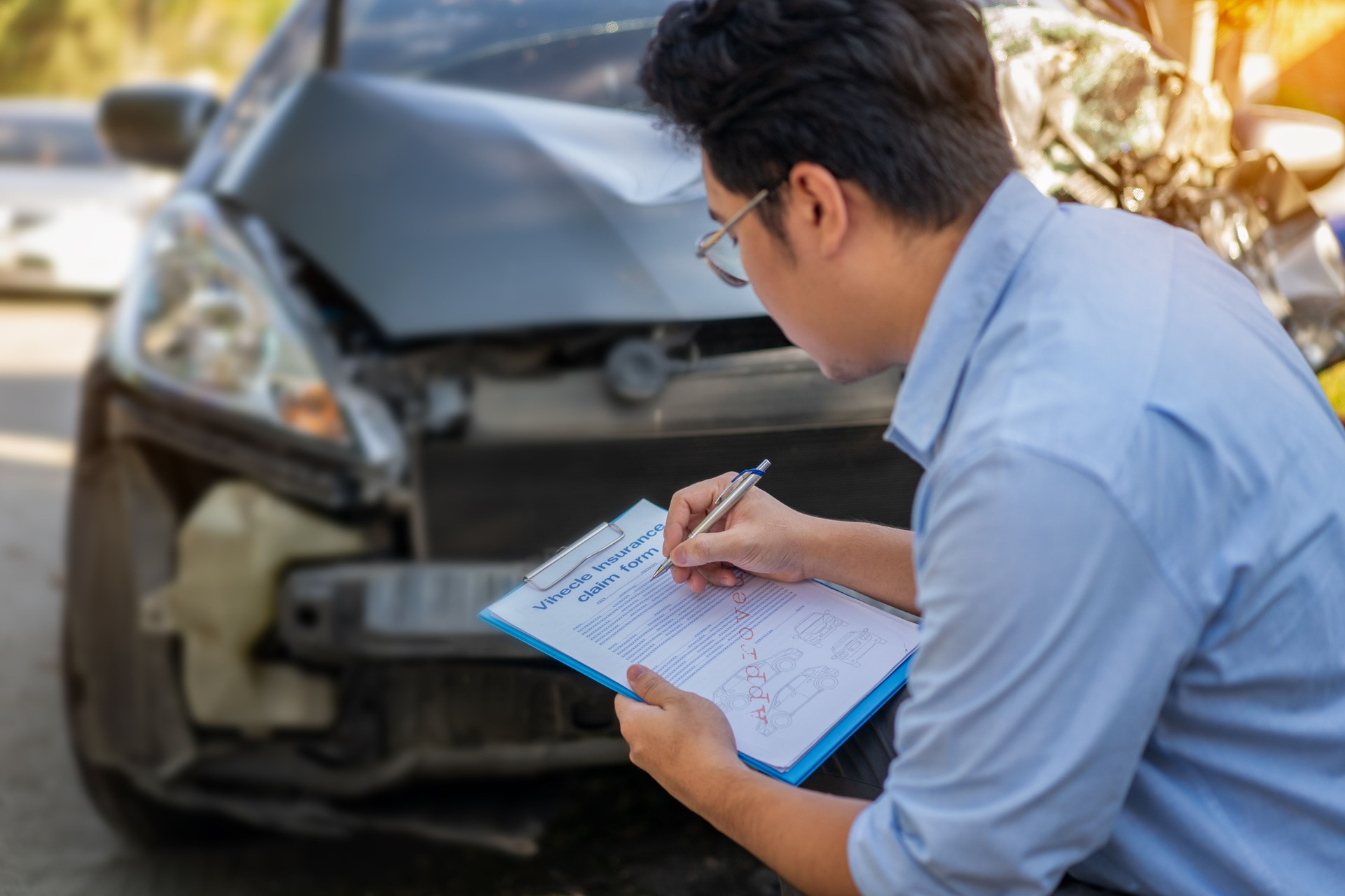 Car insurance agents inspect and evaluate damaged cars after accidents, recording them as evidence for insurance claims.